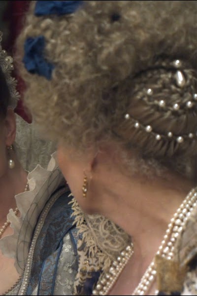 Cascading pearls, blue brocade: Every detail a display of ambition.